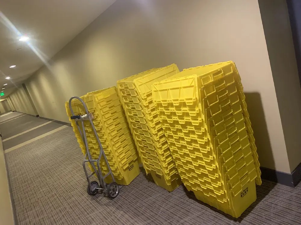 Commercial office moving crew transporting wrapped equipment